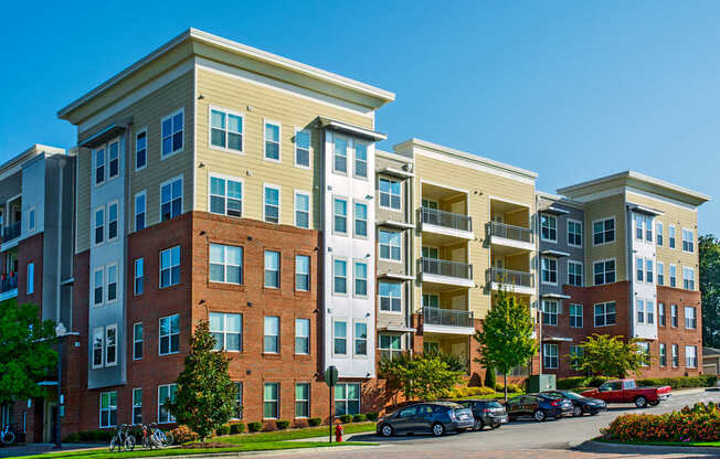 Apartment complex with a parking lot in front.