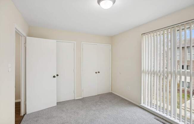 A room with three white doors and a balcony with a railing.