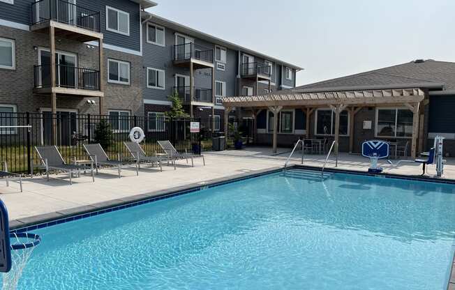 Sparkling blue pool surrounded by lounge chairs.