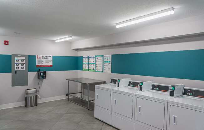 a laundry room with washers and dryers and a table