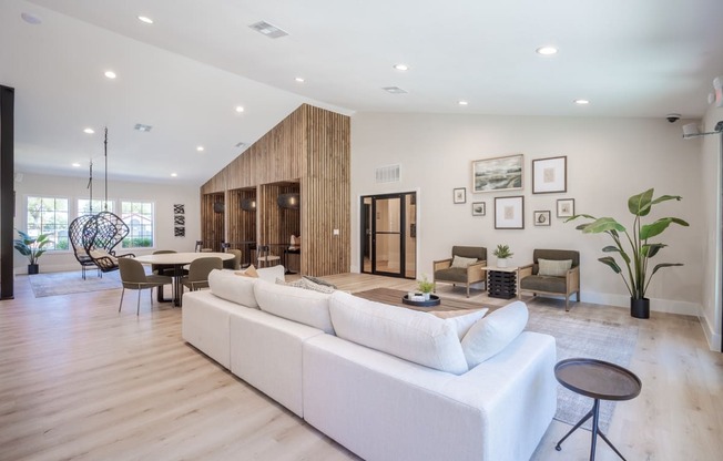 a living room with a white couch and a table and chairs