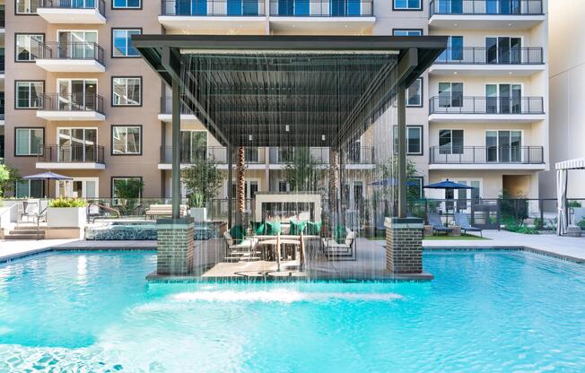 Our resort-inspired pool features a dramatic rain curtain and shaded seating area, perfect for relaxing or socializing in style.