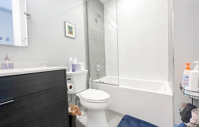 a bathroom with a white toilet next to a white bathtub