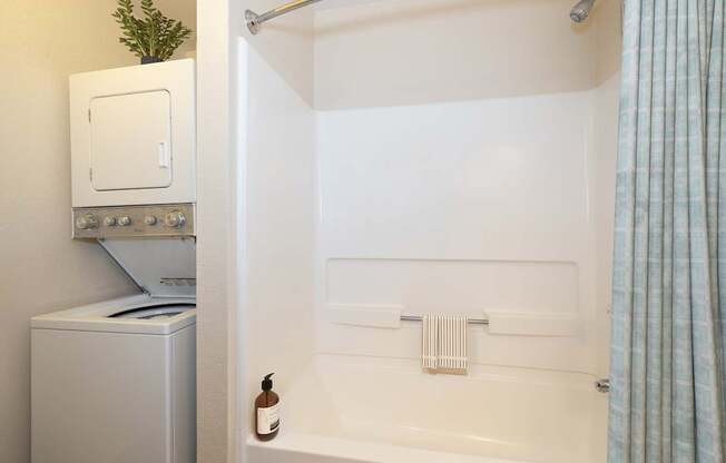 A white bathroom with a white tub and a white oven.