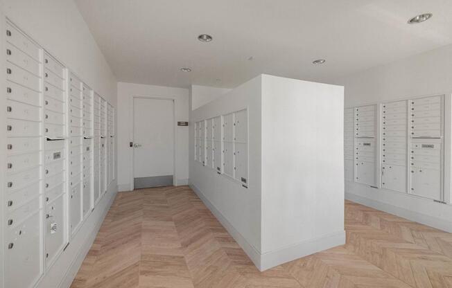 A hallway with a white wall and a wooden floor.