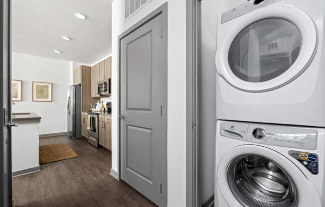 a white washer and dryer in a white laundry room with a white door at Palm Grove in Ellenton, FL 34222