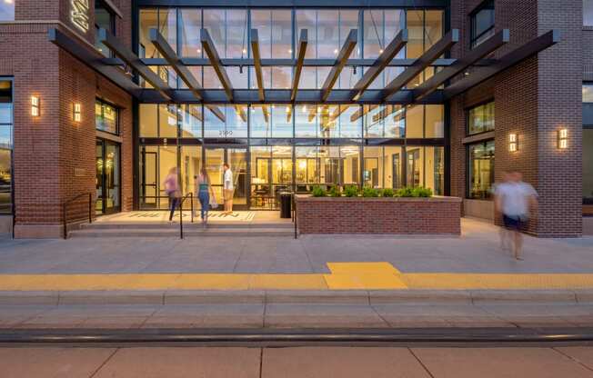 the entrance of a building with people walking in front of it