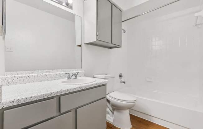 A white bathroom with a toilet, sink, and bathtub.