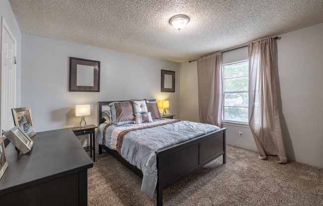 a bedroom with a bed and a dresser and a window