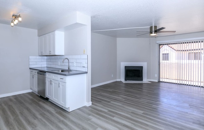 an empty living room with a kitchen and a fireplace at Tides at Mesa, Mesa, AZ, 85204