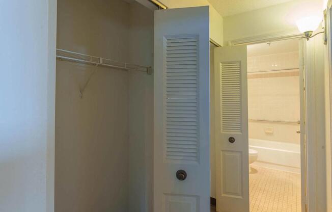 A white door with a black handle is open to a bathroom.