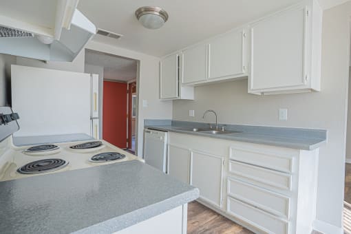 a kitchen with white cabinets and a stove and a sink at Parkside Gardens Apartments, Sparks Nevada  