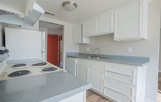 a kitchen with white cabinets and a stove and a sink at Parkside Gardens Apartments, Sparks Nevada  