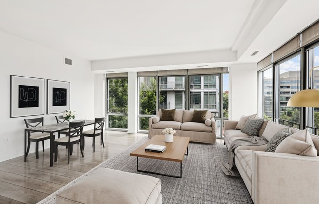 a living room with couches and a coffee table   and a dining table