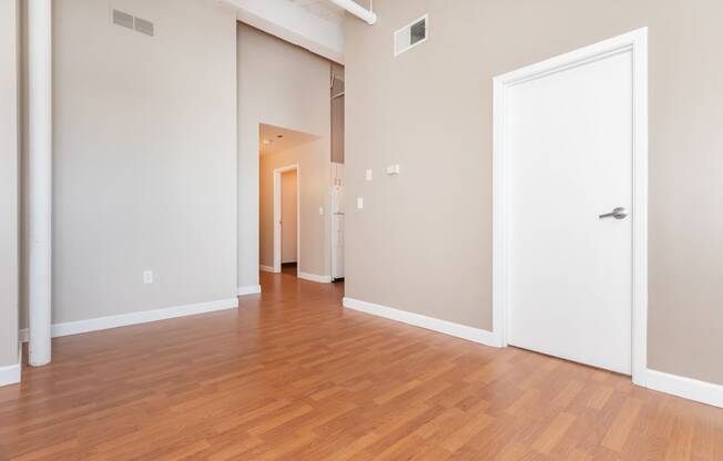 a living room and hallway with wood flooring and a white door