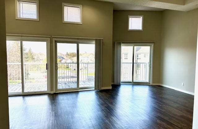 an empty living room with a wood floor and sliding glass doors