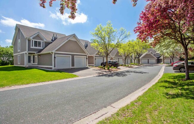 an empty street in front of a row of houses with trees