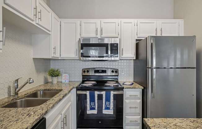 A kitchen with a stove, microwave, and refrigerator.