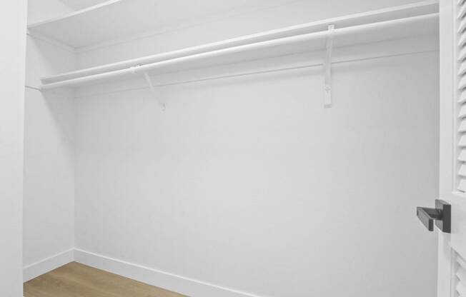 an empty room with a white wall and a white closet