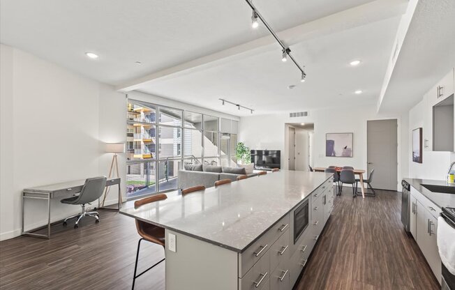 A modern kitchen with a long island and stainless steel appliances.