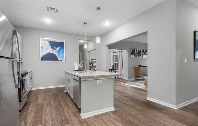 the kitchen with an island and living room  at Aurora Luxury Apartments in Madison AL