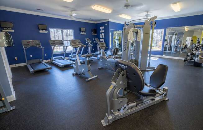 A gym with treadmills, exercise bikes, and weight machines.