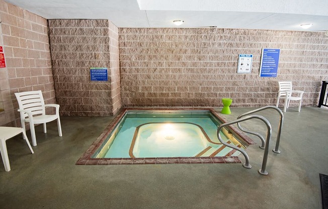 a hot tub in a room with chairs and a table