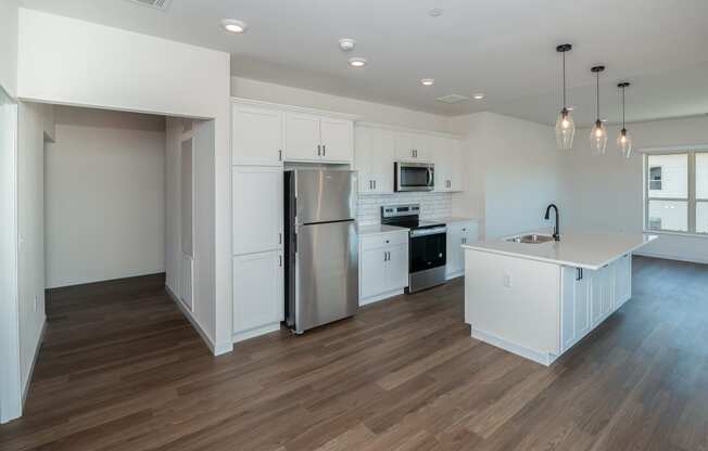 a kitchen with white cabinets and a stainless steel refrigerator at The Crossings at Windsong, Arizona