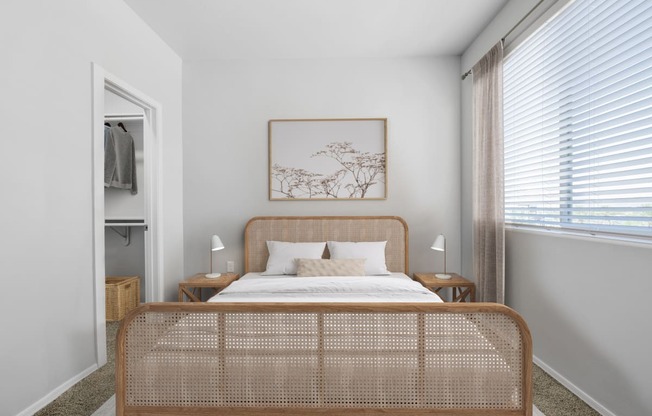 a bedroom with a large window and a bed with a rattan headboard