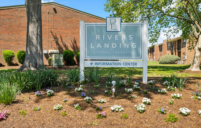 A sign for Rivers Landing is in front of a building.