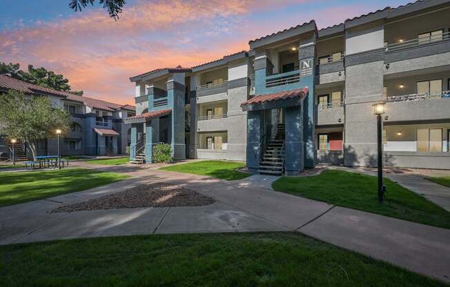 Sunset view of Stillwater apartment buildings with a courtyard in the foreground.