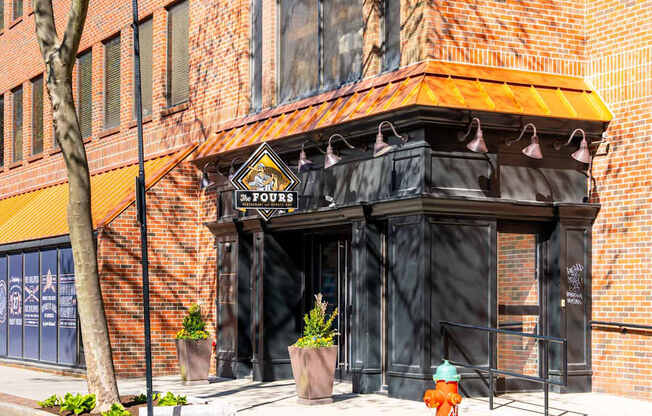 A building with a black awning and a fire hydrant in front of it.
