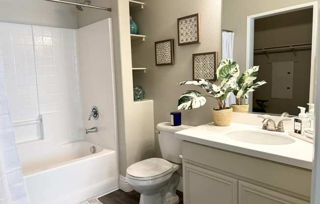 a bathroom with a white toilet next to a white bathtub