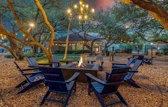A fire pit surrounded by chairs in a backyard.