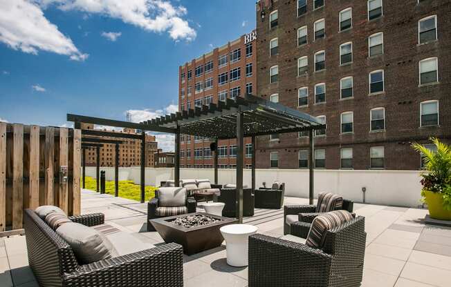 a rooftop patio with wicker furniture and a wooden fence