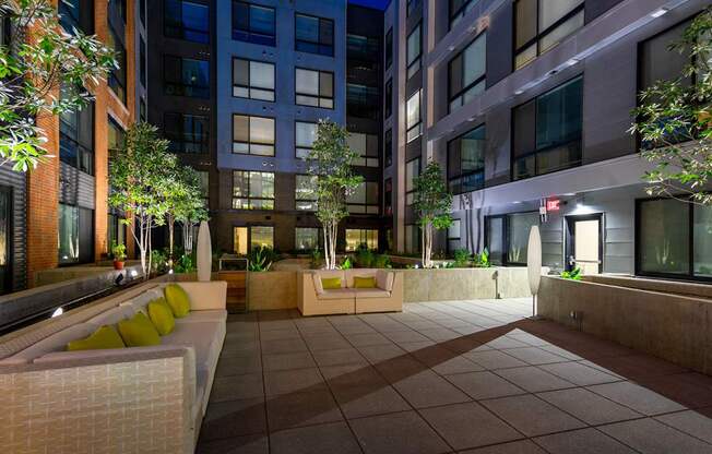 A courtyard with a bench and a tree.