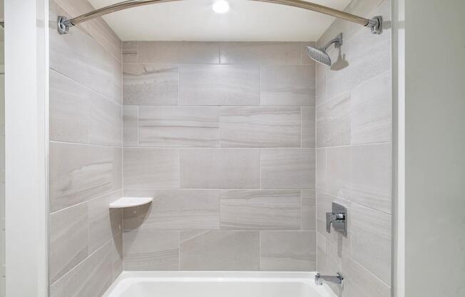 Sleek tile surrounds and polished fixtures bring a refined touch to bathrooms at Modera Aventura.