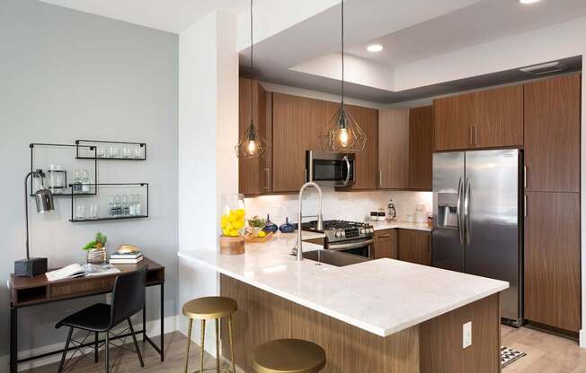 A modern kitchen with a white countertop and wooden cabinets.