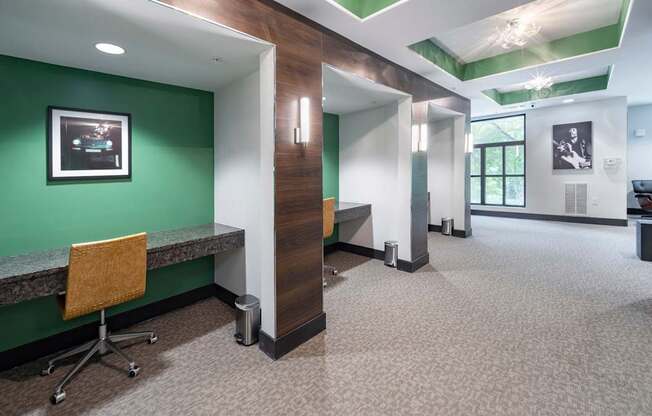 a hallway with a green wall and a desk with a chair at The Hendrix, Atlanta, GA