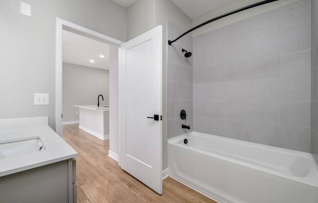 a white bathroom with a tub and a sink