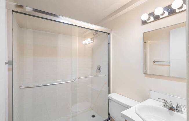 a bathroom with a shower and a sink and a toilet