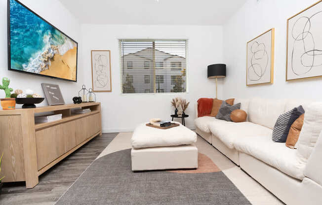 A modern living room with a white couch and a wooden entertainment center.