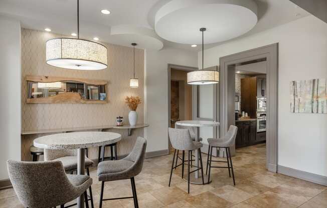 a dining area with tables and chairs and a kitchen in the background