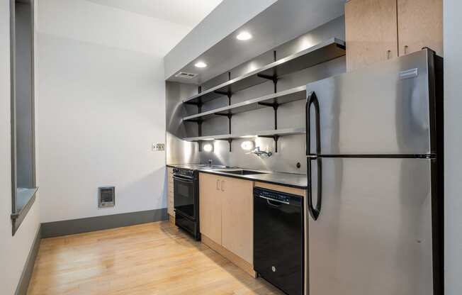 a kitchen with stainless steel appliances and wooden cabinets and a refrigerator