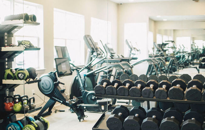 a gym with weights and racks of dumbbells