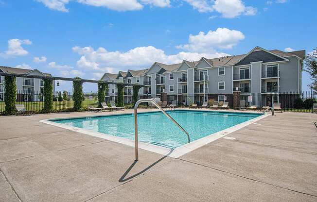 A swimming pool in front of apartment buildings at The Reserve at The Reserve at Destination Pointe in Grimes, IA 50111