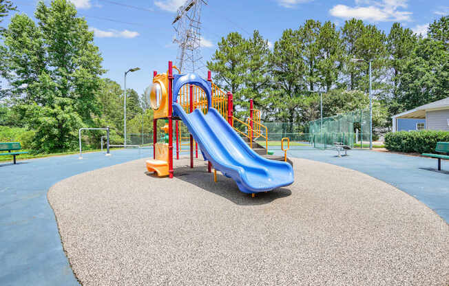 A playground with a blue slide and a red and yellow structure.