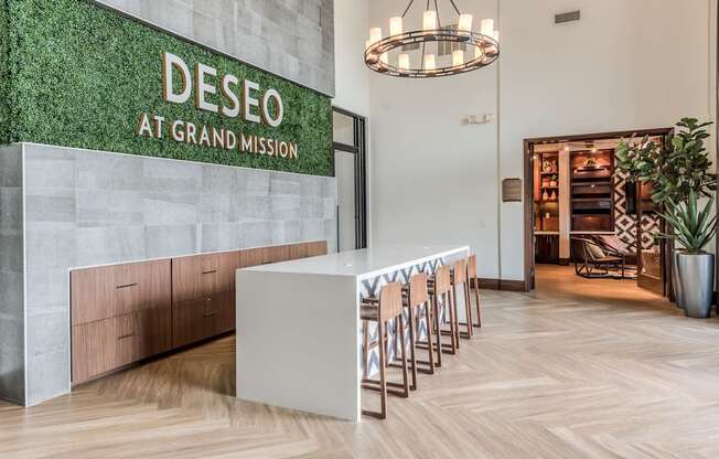 A reception area with a green wall and a white reception desk.