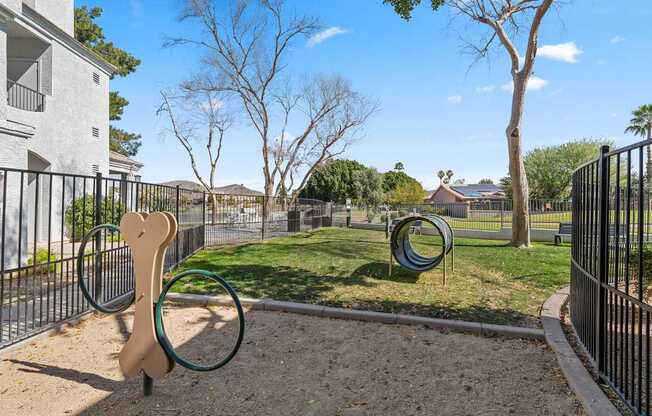 A playground with a wooden swing and a green metal ring.