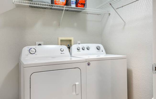 A white washing machine and dryer in a small laundry room.